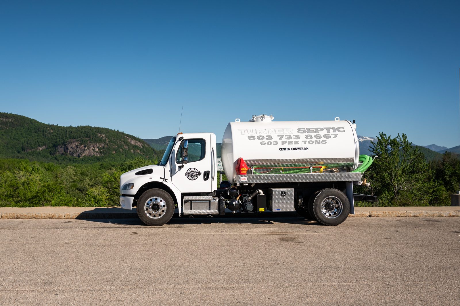 A Turner Septic pump truck parked with the Mount Washington Valley behind it.